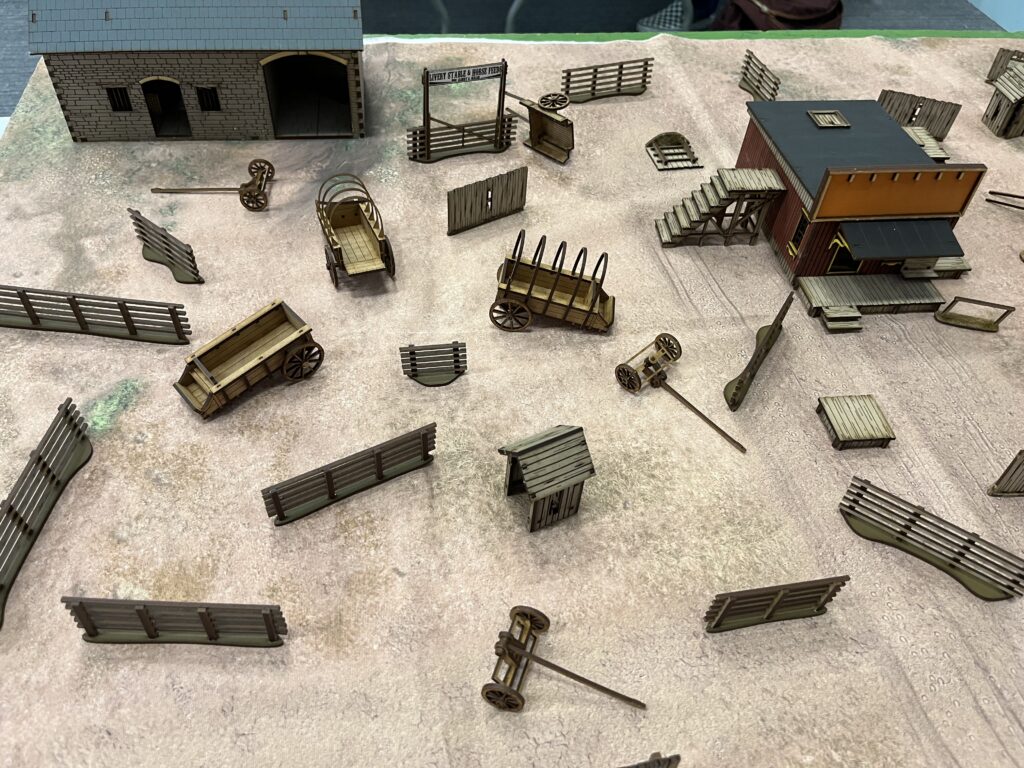 A tabletop layout of farm buildings and fences. They are scattered haphazardly in a way that prevents line of sight being drawn for more than 30 centimetres