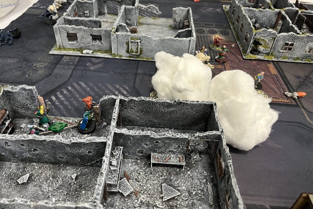 Zoomed out shot of the table showing the left hand side of it. Smoke has been deployed (represented by cotton wool) to cover the Void Dragons from the zombies and the other crew
